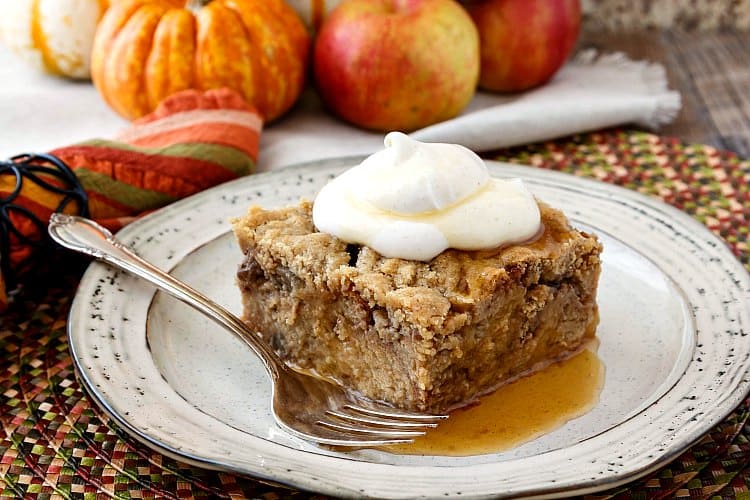 A serving of donut French toast casserole made with apple cider donuts and apple pie filling on a plate with a fork.