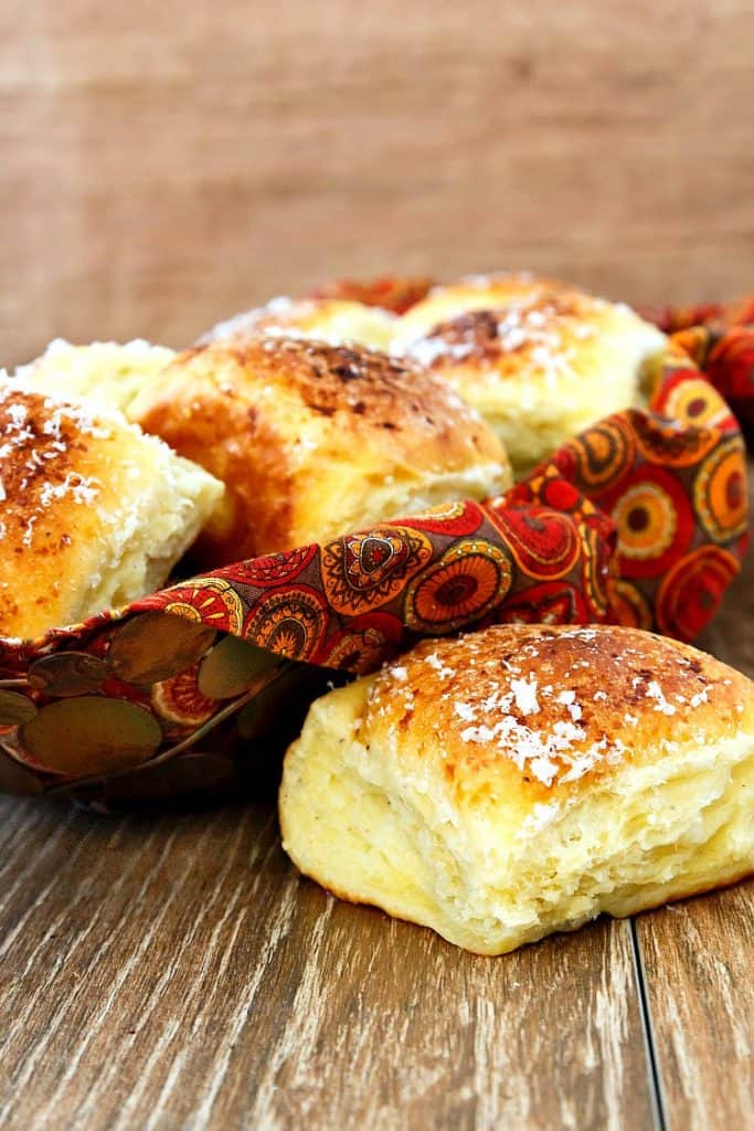 A basket of dinner rolls topped with grated Parmesan cheese.