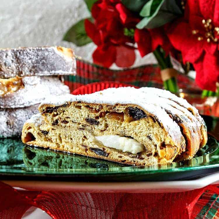 A bright green platter with slices of Christmas stollen made with potatoes displayed.