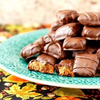 A green plate with a pile of chocolate-covered crunchy peanut butter candies.