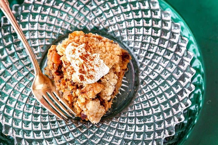  Streusel topped breakfast or brunch baked oatmeal or Christmas breakfast, with whipped cream on a glass plate.