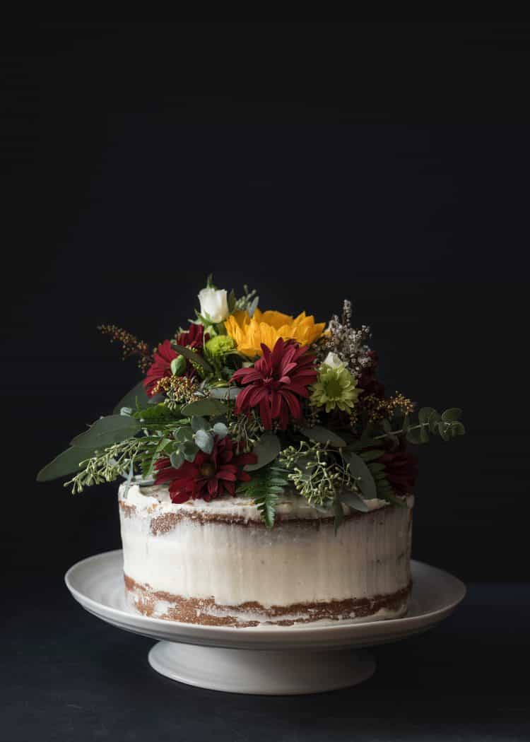 white "naked" iced cake with flowers on top as decoration