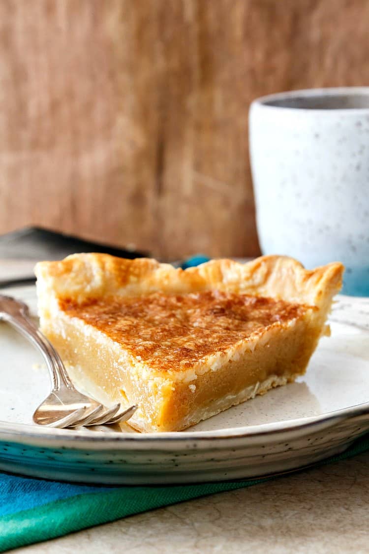 A slice of vinegar pie on a plate with a fork.