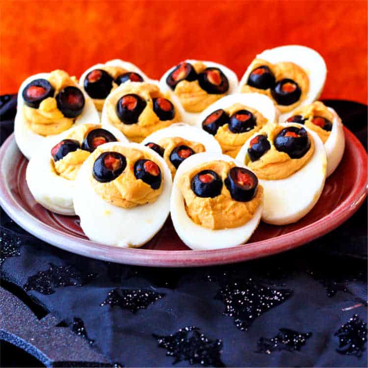 Halloween deviled eggs on a small plate.