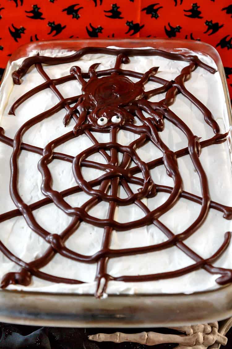 homemade eclair cake decorated for Halloween with a ganache spiderweb