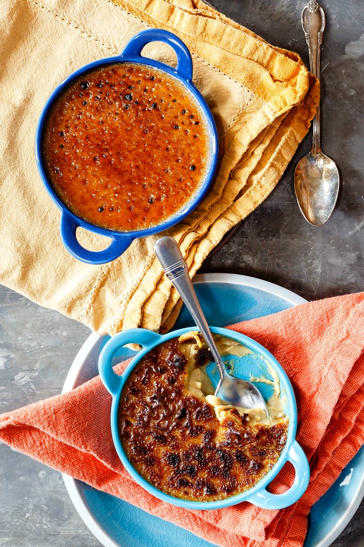 Two ramekins of butterscotch crème brulee, one on a blue plate and one on a yellow napkin.
