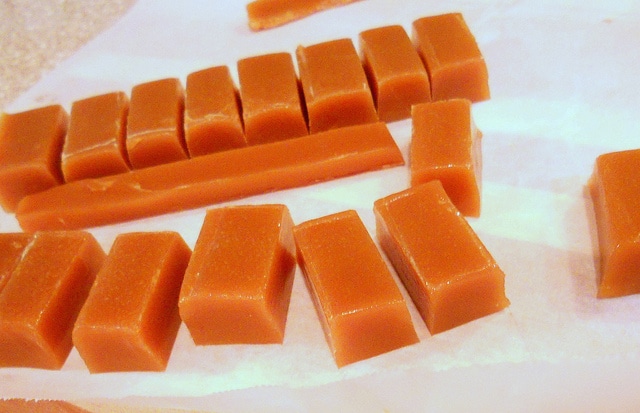 Cut pieces of chewy butterscotch candy on a piece of parchment paper.