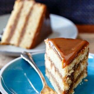 slice of golden 3 layer cake with caramel colored icing