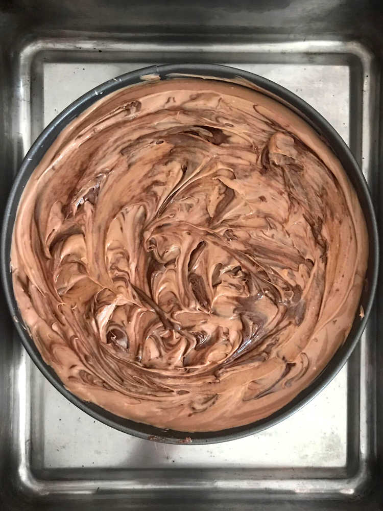 Overhead image of cheesecake with nutella swirled into the batter before baking.