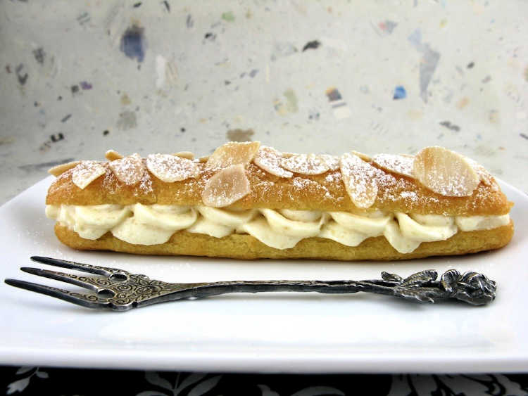 an eclair topped with sliced almonds and filled with no egg frangipane filling