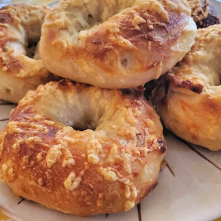 a plate of asiago cheese bagels stacked up