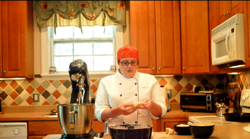 pastry chef in a kitchen with a mixer showing people how to do the creaming method