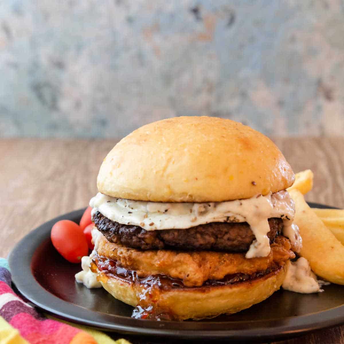 burger on a plate with fries and tomatoes