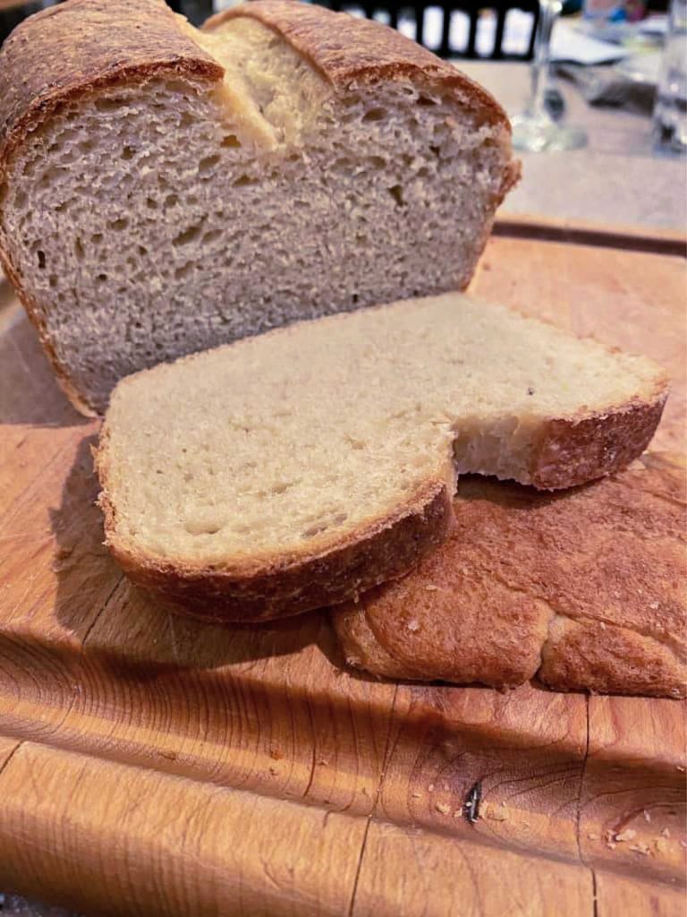 A loaf of bread, with one slice cut off. 