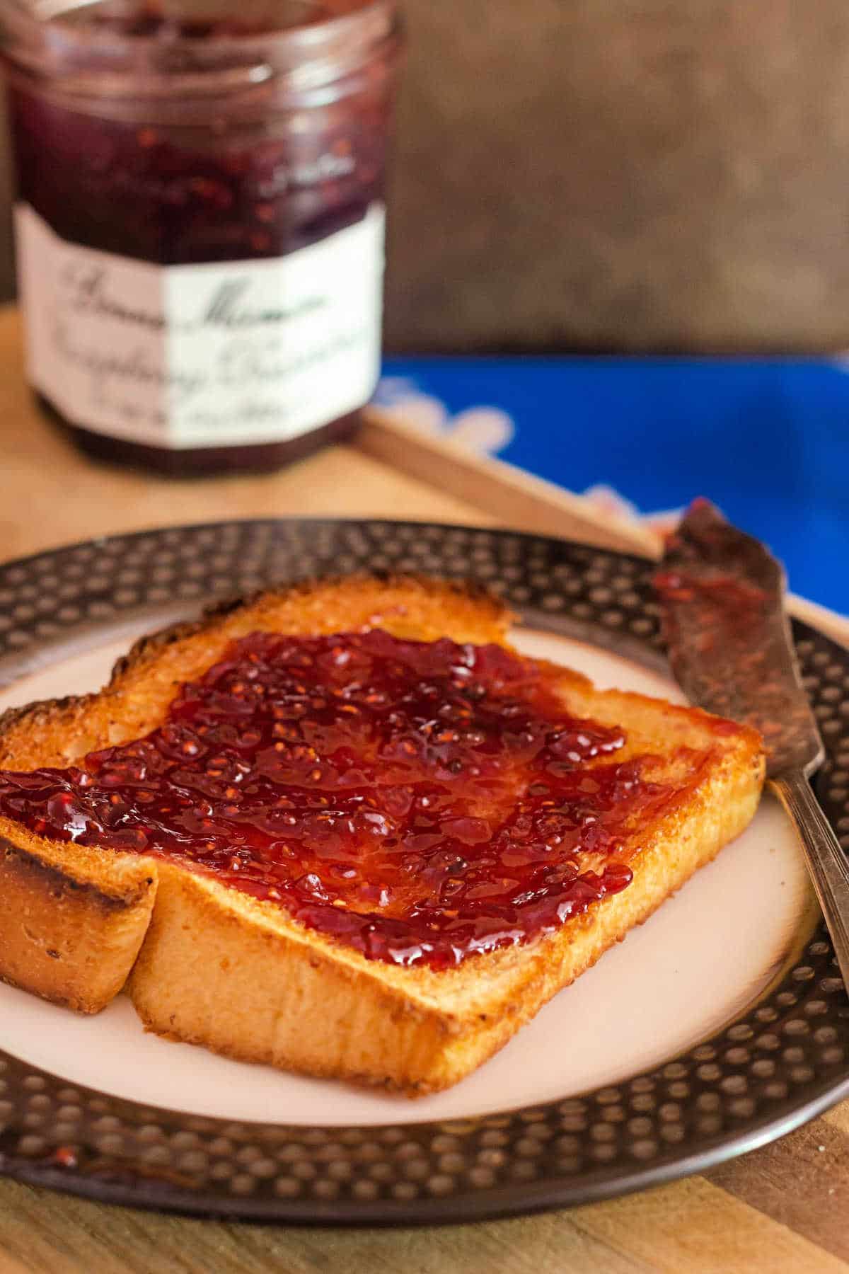 Toasted grits bread slice with raspberry jam.