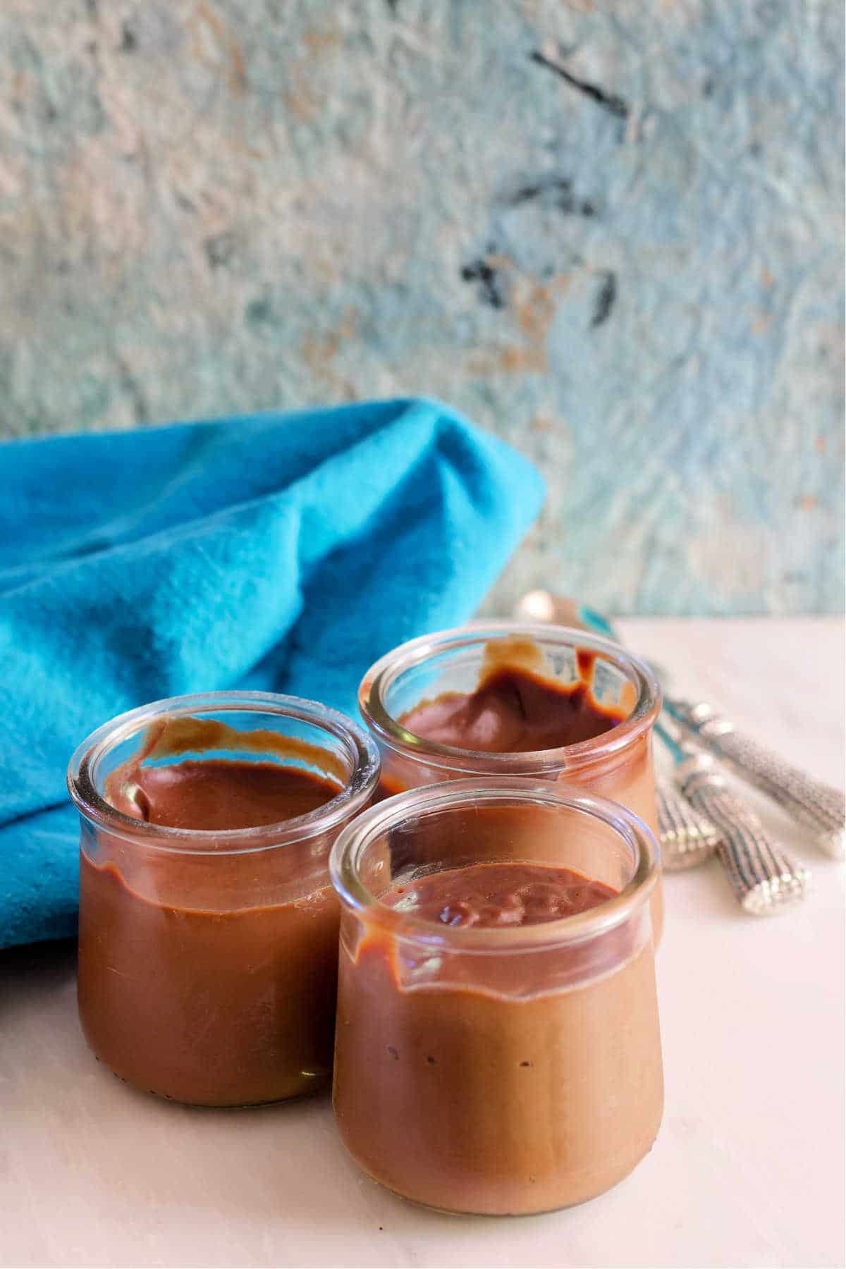 3 glass jars of chocolate caramel pudding.