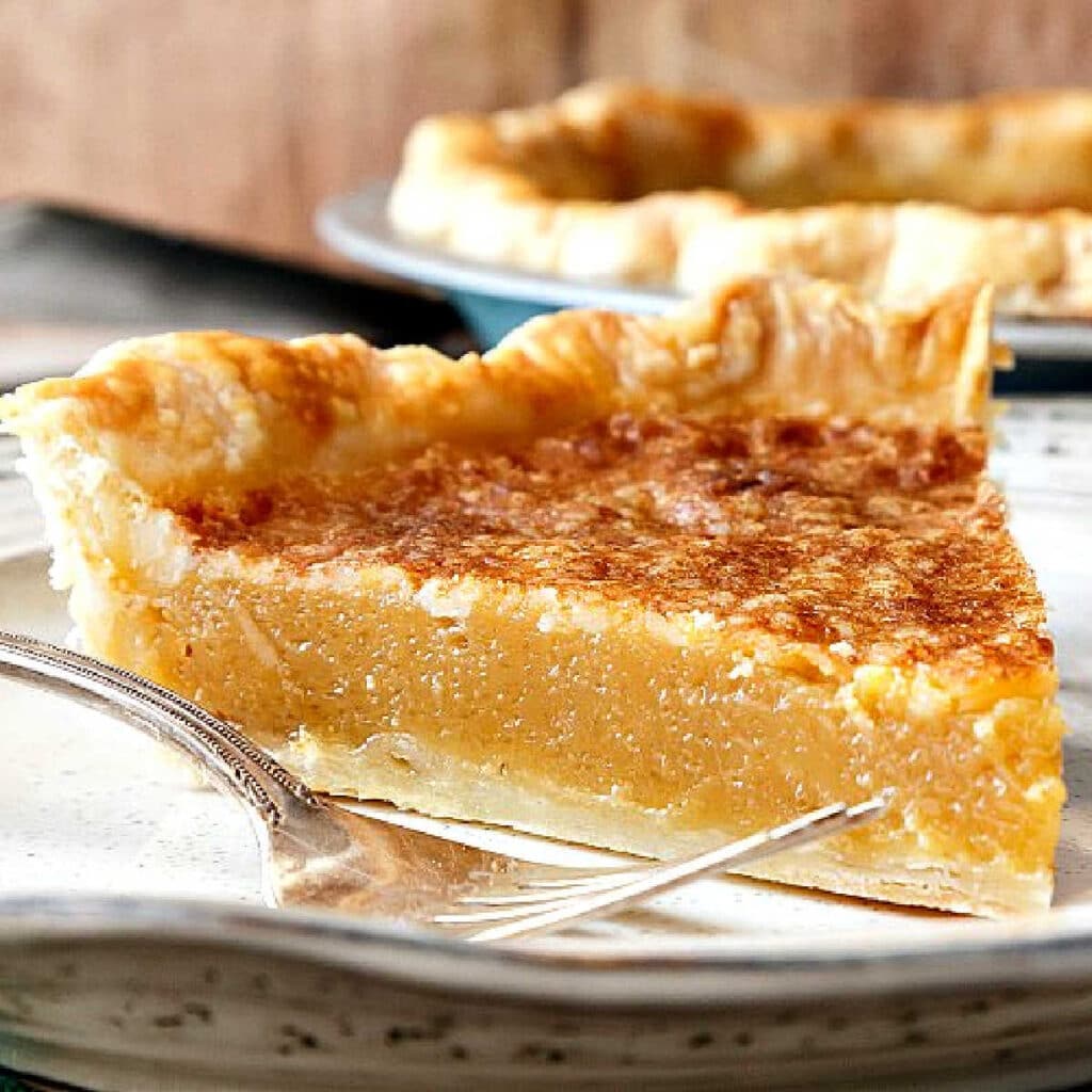 A close-up shot of a slice of pale beige pie with a broiled top.