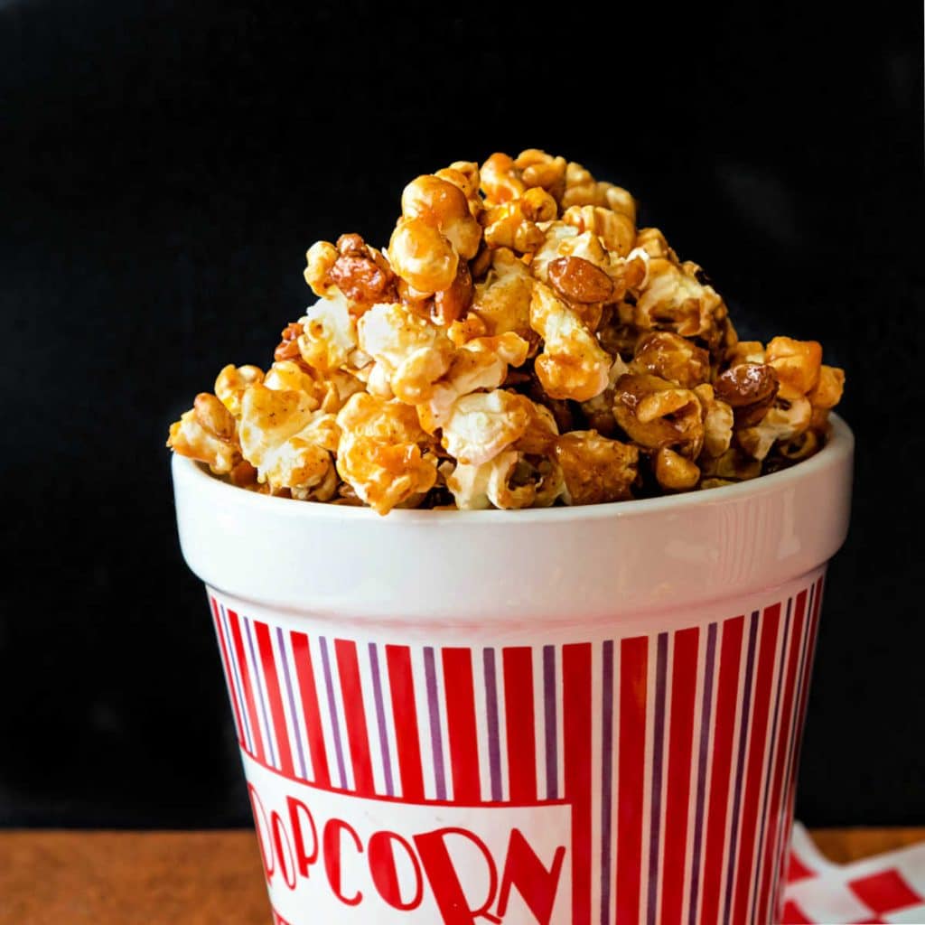 A ceramic popcorn container full of pumpkin spice caramel popcorn.