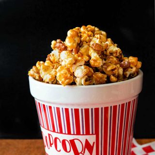 a ceramic popcorn container full of spiced caramel popcorn