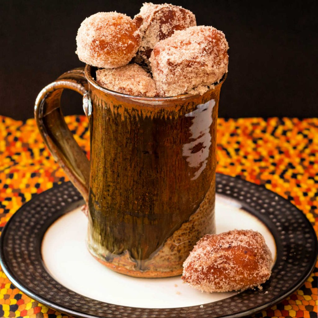 A brown mug full of pumpkin spice donut holes.