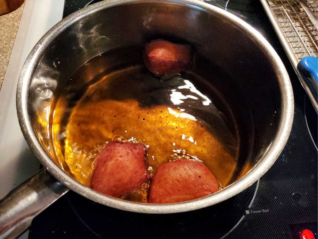 doughnuts frying in a pan of oil