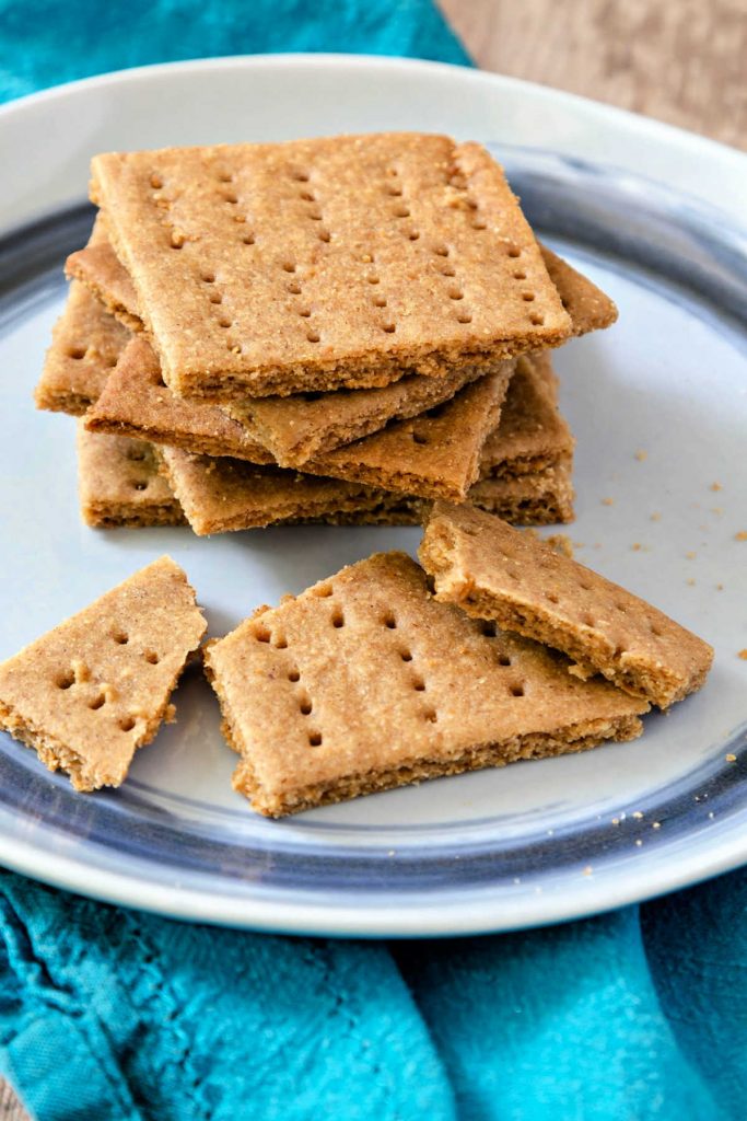 Homemade graham crackers stacked on a plate.