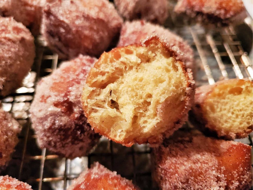 Fried pumpkin spice donut holes cut in half to see the inside crumb.
