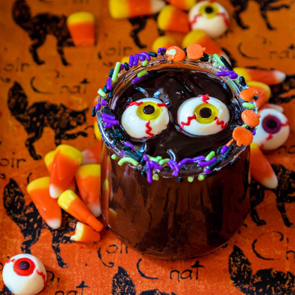 Close up of easy chocolate pudding in a dish with Halloween sprinkles and candy eyes.