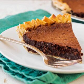 A slice of chocolate pie on a white plate with a fork.