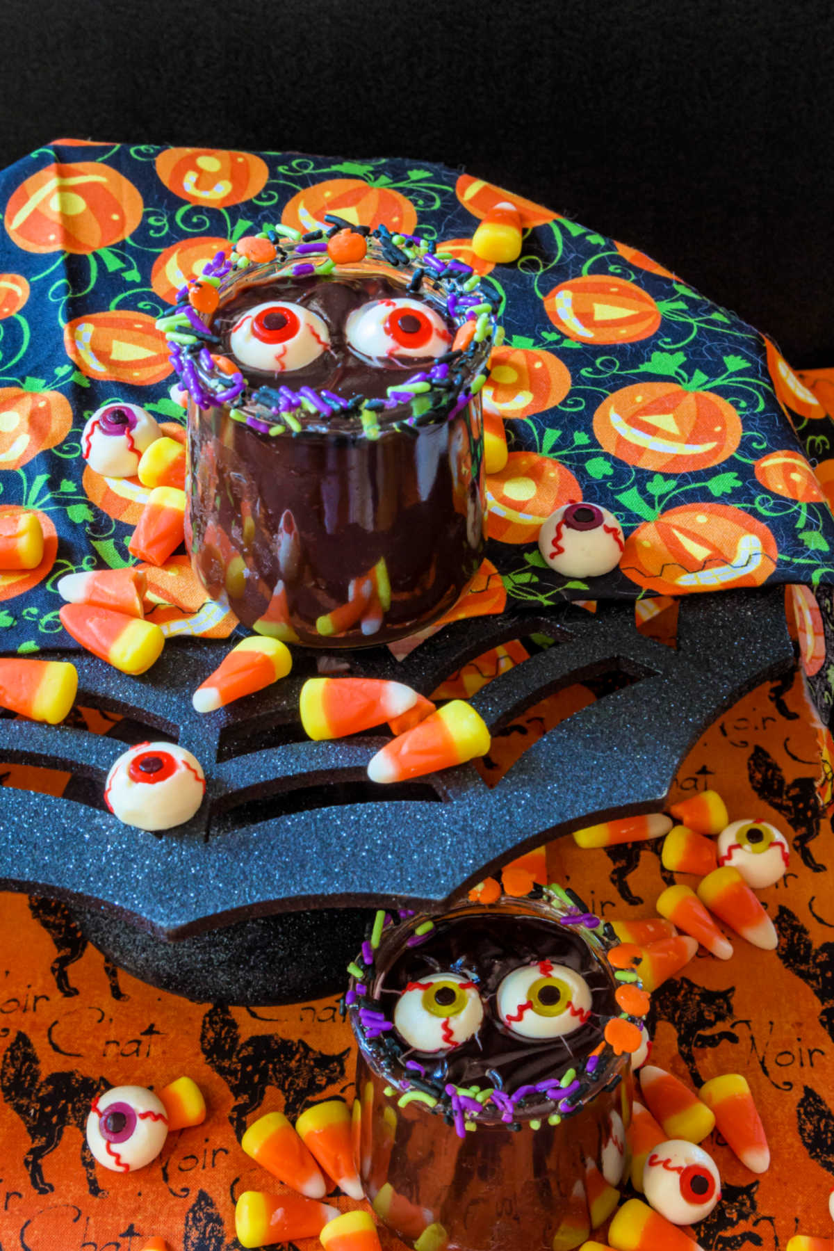 2 jars of easy chocolate pudding decorated for Halloween with Halloween candy.