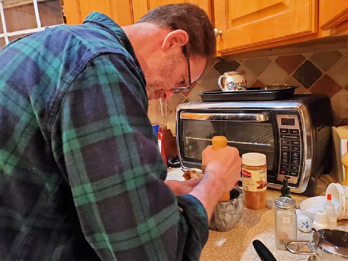 A man grinding spices using a mortar and pestle.