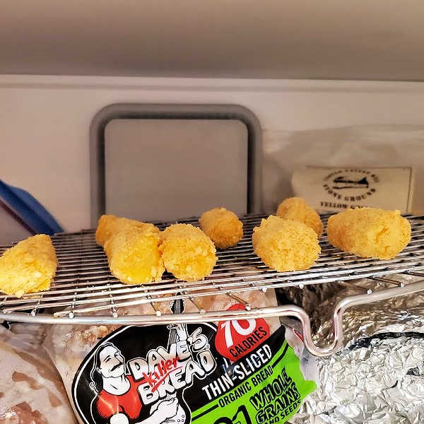 frozen mozzarella sticks on a rack in the freezer