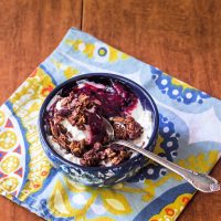 A bowl of yogurt with granola and jam.
