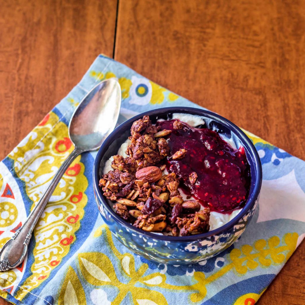 A bowl of yogurt topped with granola and homemade jam.