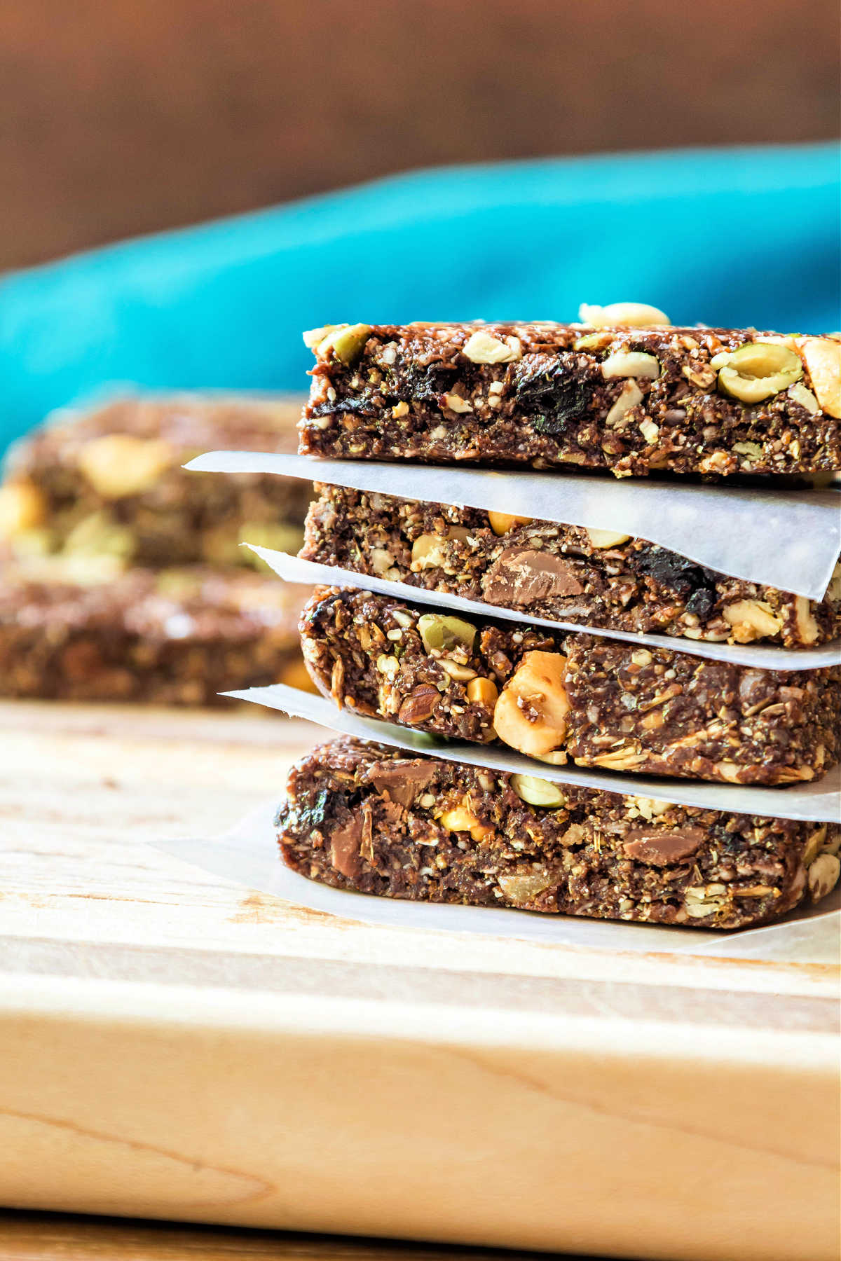 A stack of four no-bake granola bars with waxed paper between them.
