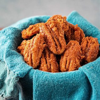 A close-up of candied pecan halves in a blue napkin.
