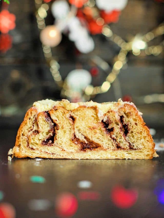 a slice of breakfast pastry with Christmas decorations in the background.