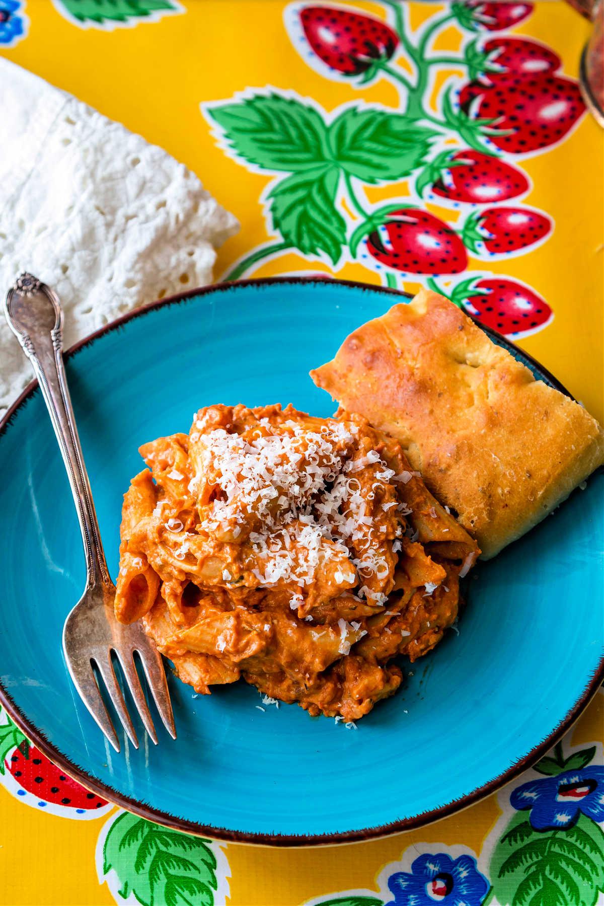 penne alla vodka on a blue plate with focaccia.