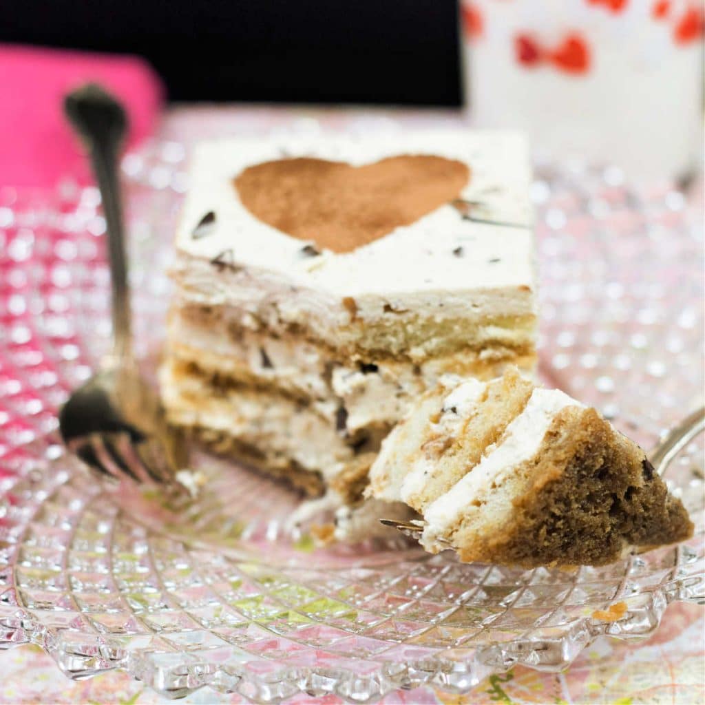 A square slice of tiramisu with a bite cut from it.