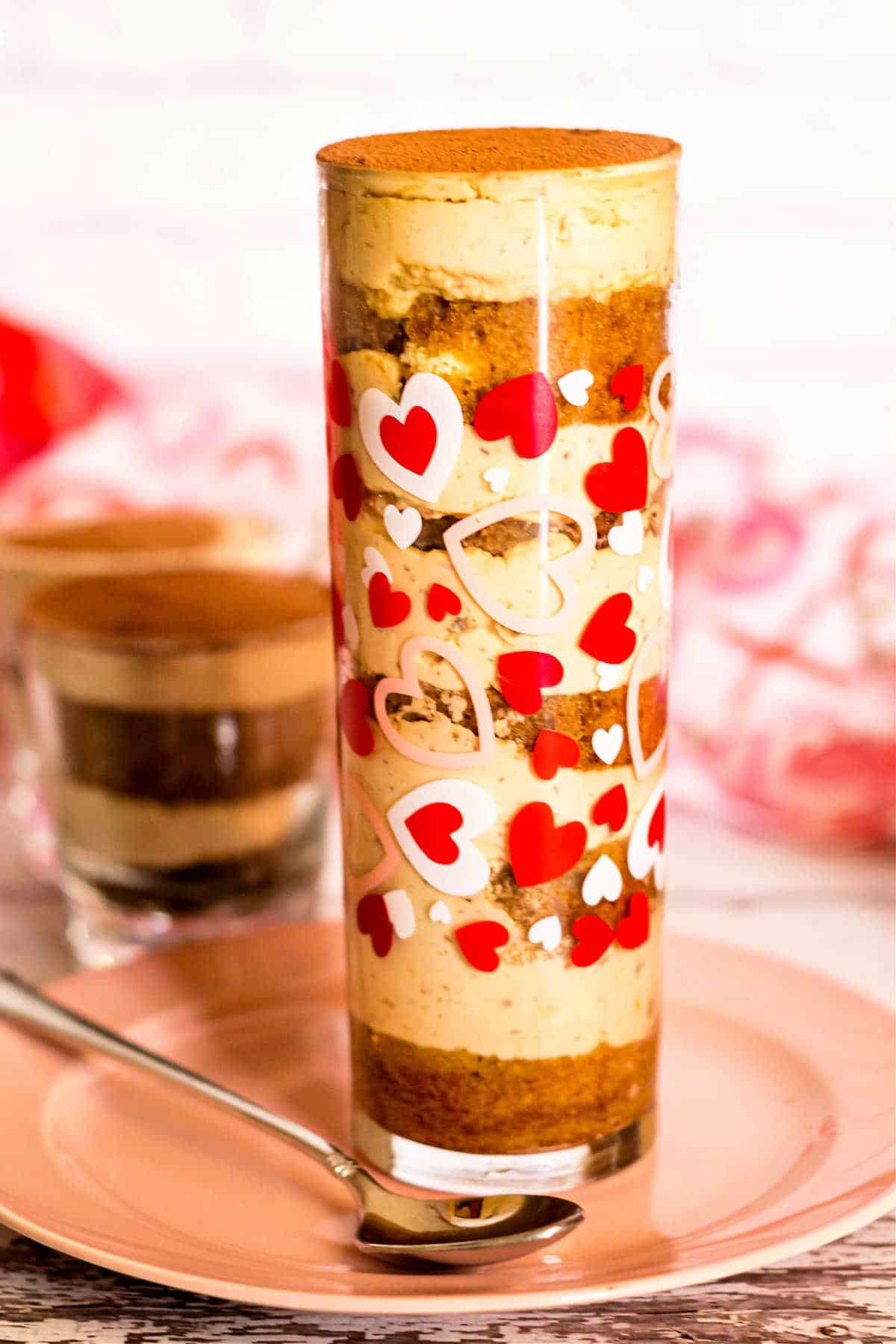 An individual tiramisu layered in a tall, skinny glass.