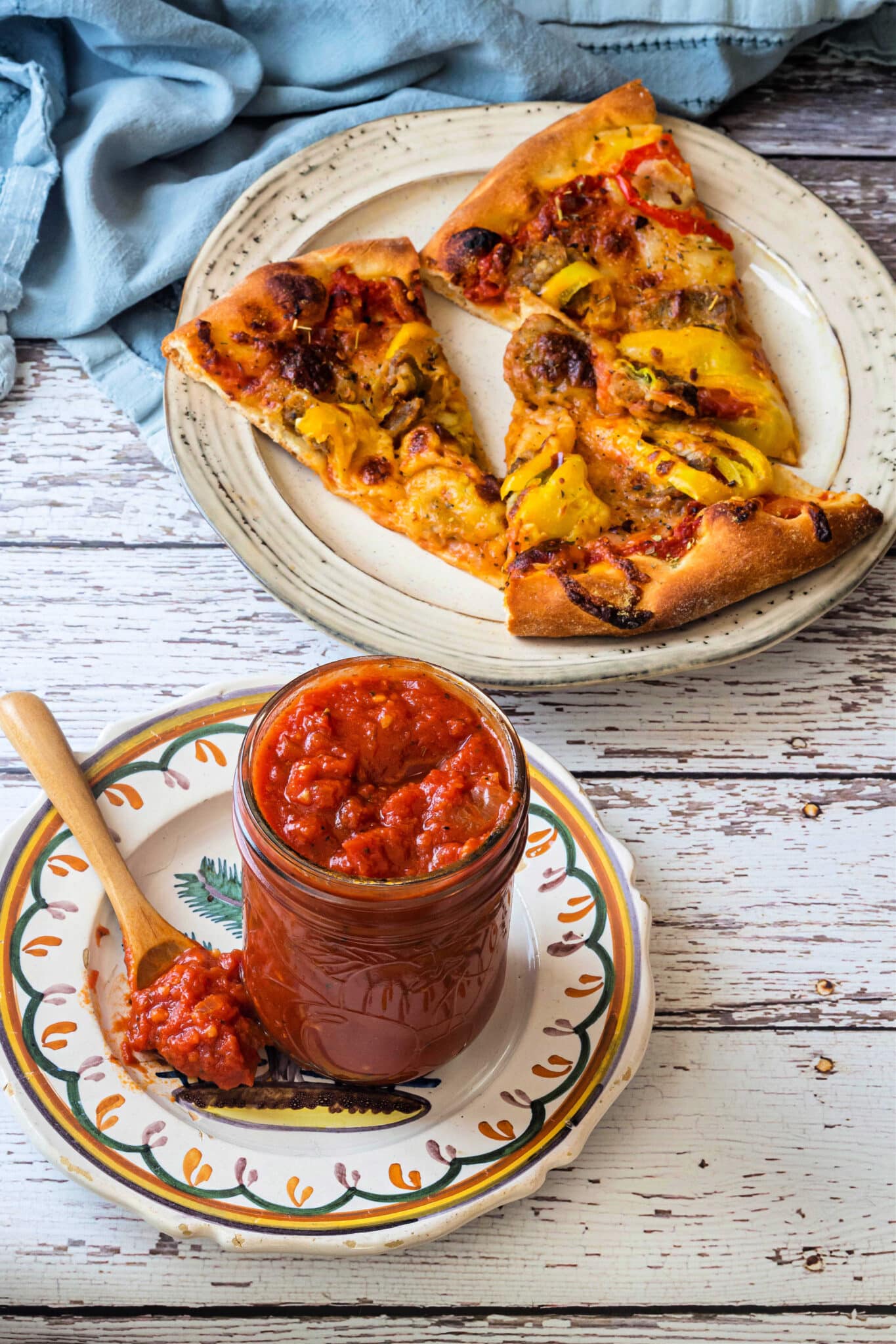 A jar of homemade pizza sauce and three pieces of pizza.