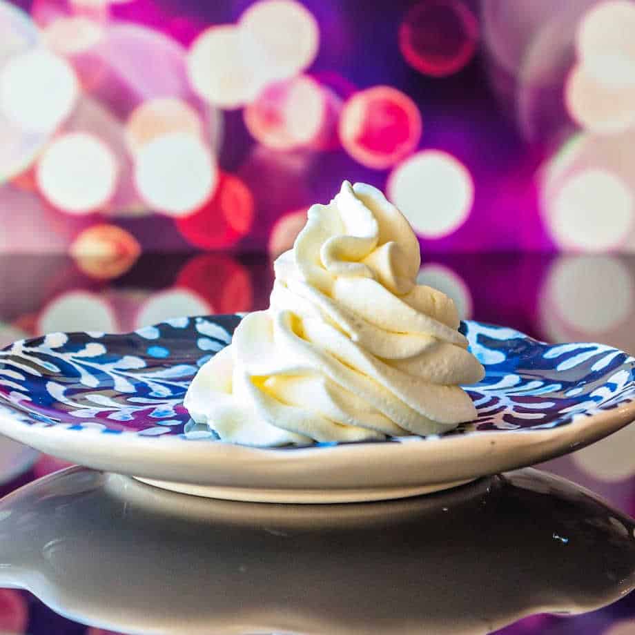 A blue and white plate with whipped cream piped on it.