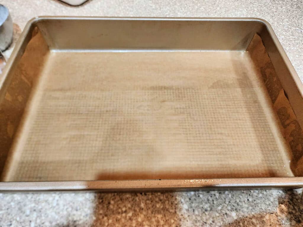 A 9 x 13" baking pan with a sheet of parchment folded to fit into the bottom of the pan snugly and extend up the sides a bit.