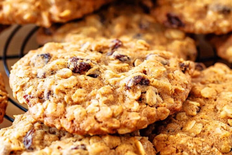 A close-up of large, thick and chewy oatmeal raisin cookies on a circular rack.
