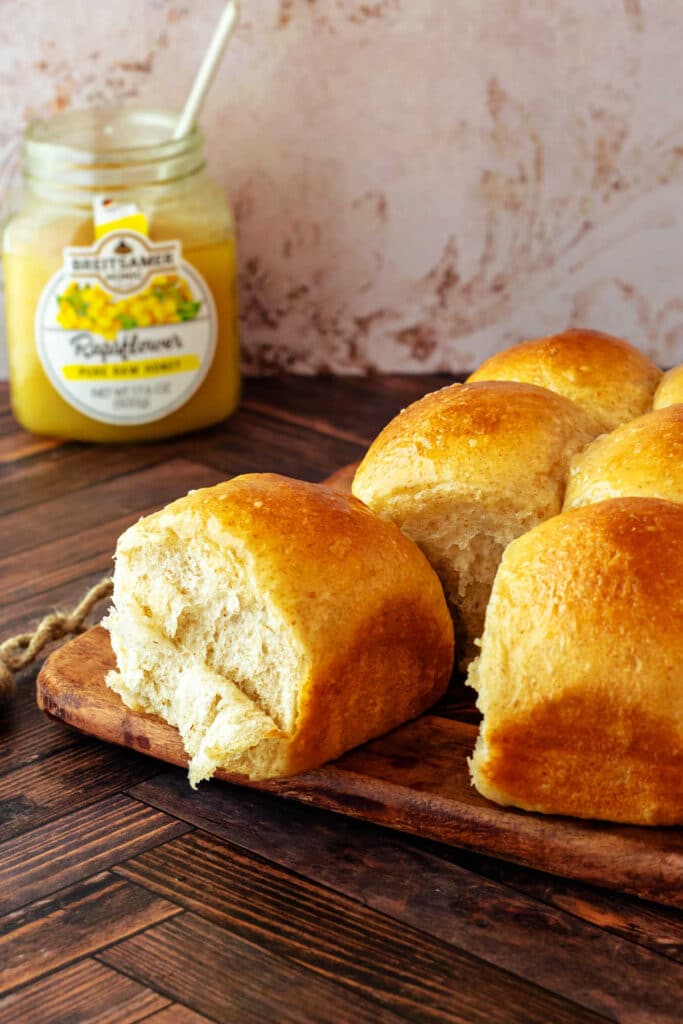 Rolls cooling on a cooling rack. One roll is pulled apart from the rest, and some of the crumb is shredding in sheets.