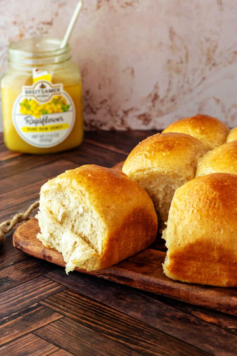 Rolls cooling on a cooling rack. One roll is pulled apart from the rest, and some of the crumb is shredding in sheets.