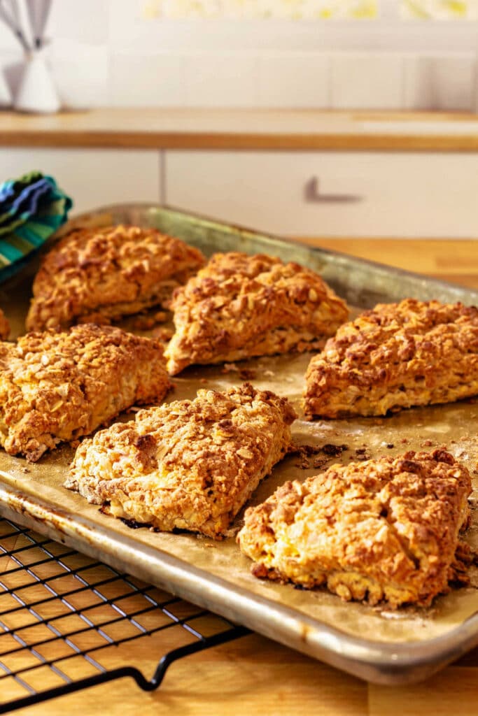 A baking tray of streusel-topped peach scones on a cooling rack.